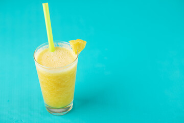 pineapple smoothie on blue background with copy space,fruity summer tropical cocktail