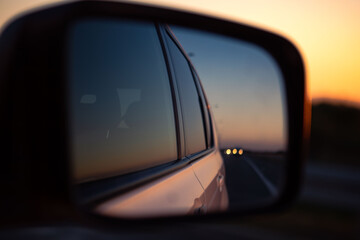 reflection in car rear mirror sunset on the road