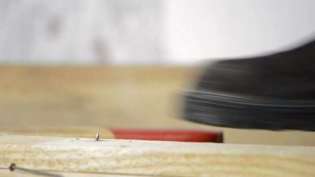 Close-up of man's foot stepping over there nail inserted in wooden plank.Home safety concept