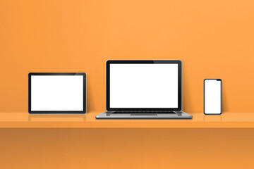 Laptop, mobile phone and digital tablet pc on orange wall shelf. Horizontal background