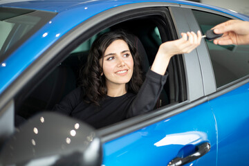 happy young woman buying a  in new car