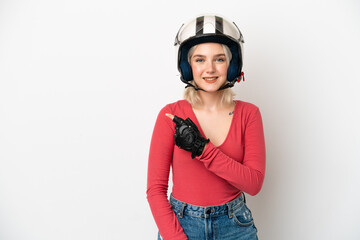 Young caucasian woman with a motorcycle helmet isolated on white background pointing to the side to present a product
