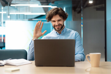Business man using laptop waving hand making video call