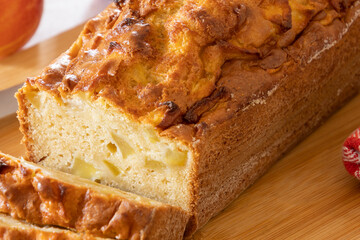 close up of a cut apple cake on a wooden board