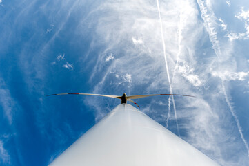 Weitwinkelaufnahme eines Windrades zur Stromerzeugung in der Froschperspektive mit blauem Himmel...