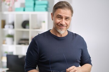 Happy middle aged good looking casual man at home, smiling. Portrait of mid adult, mature age man,