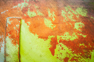 Old wall with scratched peeling orange-yellow paint. Abstract textured background. Copy space. 