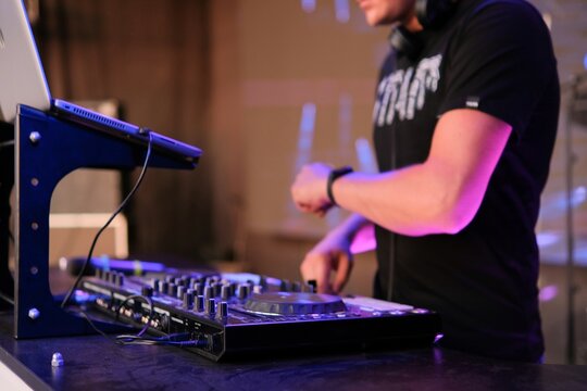 Beautiful photo of black dj controller with hands of dj