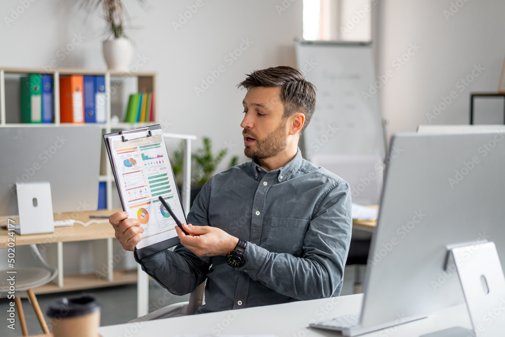 Poster Remote presentation concept. Mature male manager having video call on computer and showing document with graphs