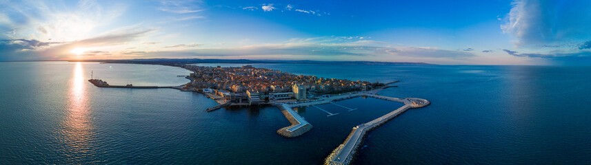 Obraz premium Panoramic view from a height above the town of Pomorie with houses and streets washed by the Black Sea in Bulgaria