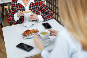 Elderly woman having cup of coffee in cafe