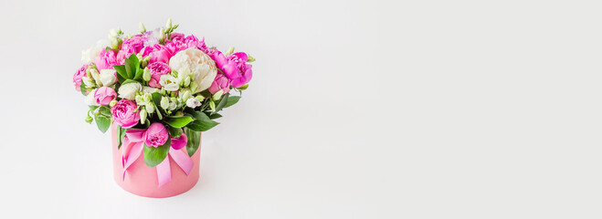 bouquet of flowers in a hat box web banner. Bouquet of peonies, eustoma, spray rose in a pink box...