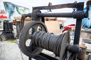 Winch with a rope on a pier with boats and boats against the sky