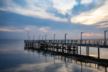 Fototapeta premium Side view of the pier on the Black Sea against the background of the sky and sunset