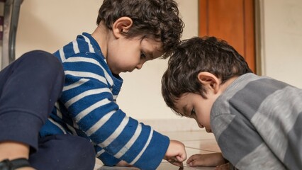 twin children playing with the cell phone on the floor of their home