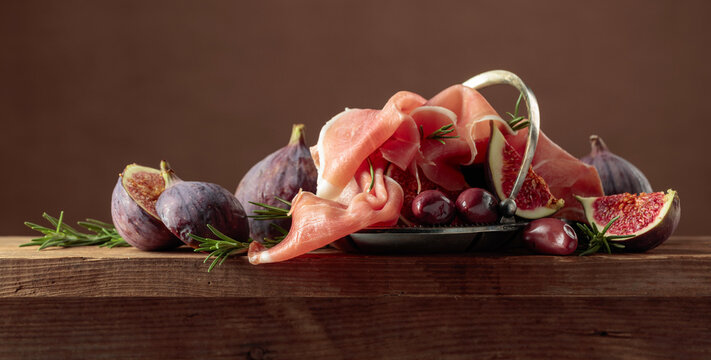 Prosciutto with figs, rosemary, and red olives.