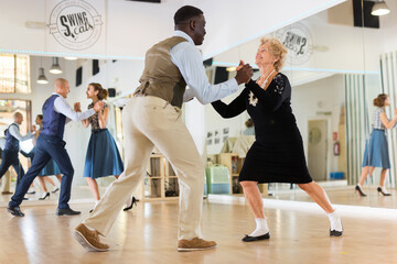 Senior womaSenior woman and man dancing swing in studion and man dancing swing in studio