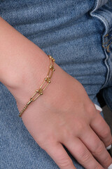 women's gold bracelet on the girl's hand, women's accessories, jewelry, gold bracelet with stones, women's jewelry, a girl with a bracelet on her arm, a bracelet with stones