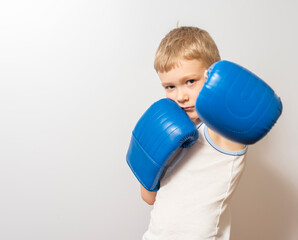 a little boy in blue boxing gloves. the concept of achieving the goal.