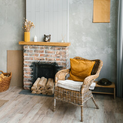 The interior of the living room in a country house. Cozy fireplace and wicker chair