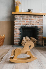 A toy wooden horse-stroller in the cozy interior of the living room