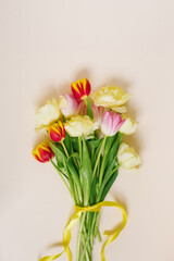 A bright spring bouquet of tulips on a beige background. Greeting card