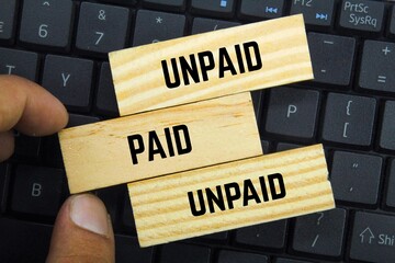 wooden boards with the words paid and unpaid - obrazy, fototapety, plakaty