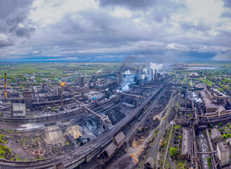 Aerial view of a large metallurgical plant for the production of metal. Blast furnaces and an oxygen production shop. Lots of pipes and chimneys. Industrial zone.