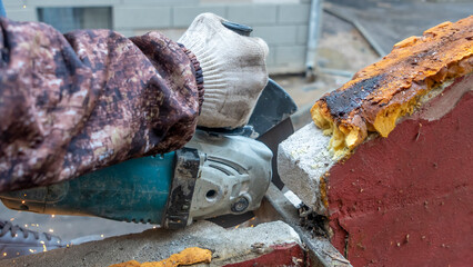 Obraz premium Close-up view of a worker working with angle grinder. Electric wheel grinding on steel structure. Sparks.