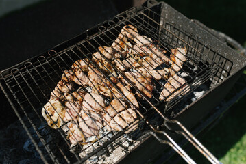 Shish kebab of chicken thighs on the grill on the grill are fried
