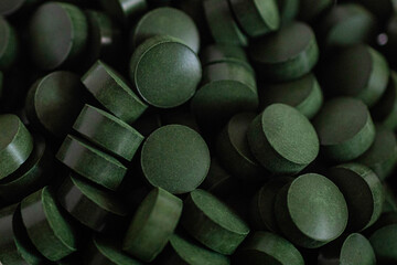 Heap of green round pills photographed close up.