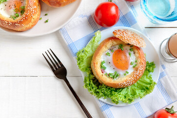 Egg baked in a soft bun with ham, fresh herbs. Delicious and quick breakfast