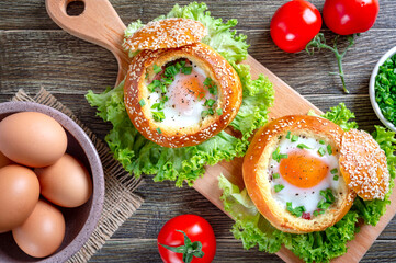 Egg baked in a soft bun with ham, fresh herbs. Delicious and quick breakfast. Top view