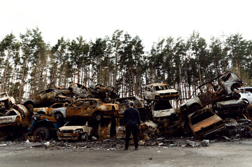Fototapeta premium rusty burnt out cars destroyed from rocket explosions. fragments of bombs pierced cars. Russian vandalism in Ukraine. war in Ukraine. destroyed cars in Kyiv, bucha and irpen.