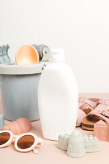 Kids summer accesories and sun screen bottle for sunny days and vacations. Sunglasses, sandals, sand molds for beach fun time