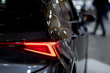 Luxury car red tail light on a dark brurred background.