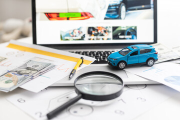 Fototapeta premium blue toy car with money and car key on wooden table.