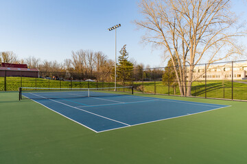 Blue tennis courts with white lines and light blue pickleball lines