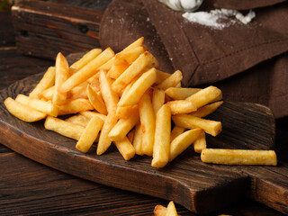 French fries on wooden background.