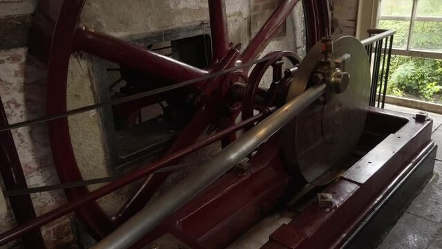 A horizontal steam engine at a working cotton mill.  Flywheel and shaft. Looping