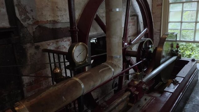 A horizontal steam engine at a working cotton mill.  Flywheel and shaft. Looping