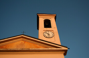 ミラノの教会の十字架と鐘と古時計、夕方の静寂なアンビエント