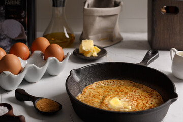 Préparation la pâte pour crêpes, blinis, pancakes. Les ingrédients sur une table: beurre,...