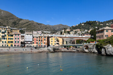 Scenic view of the small port ("Porticciolo") of the old fishing village with the typical colorful houses and the railway arch bridge in spring, Nervi, Genoa, Liguria, Italy