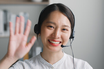 Close up of Young Asian woman wearing headphone, call center, customer service and smiling waving....