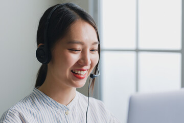 Asian woman call center, customer service, telesales in formal suit wearing headset or headphone talking with customer in office