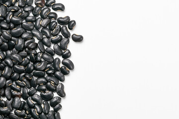 Top view of uncooked black beans on white background with copy space.