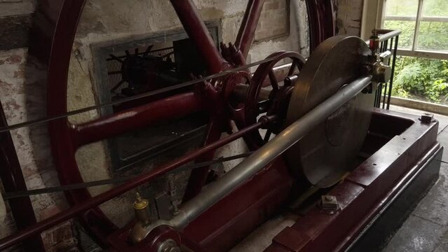 A horizontal steam engine at a working cotton mill.  Flywheel and shaft