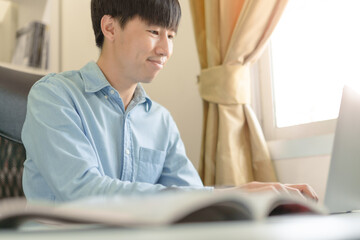 Fototapeta premium Businessman, Trader, investor using laptop for money trading, investment on stock market, Bitcoin Cryptocurrency on online platform. Student man studying business strategy, education learning online.