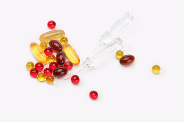 Vitamins, pills, glass ampoule and tablets on light gray copy space background.